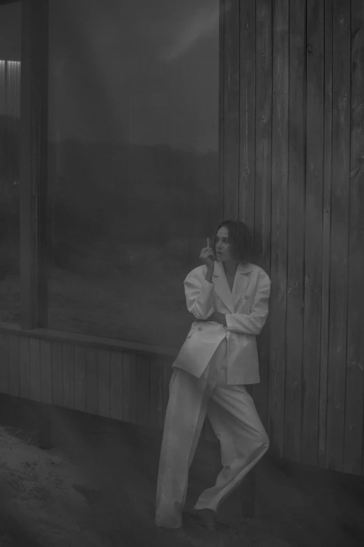 a black and white photo of a man in a suit, inspired by Peter Lindbergh, bauhaus, wearing white pajamas, stood outside a wooden cabin, billie eilish, warpaint aesthetic