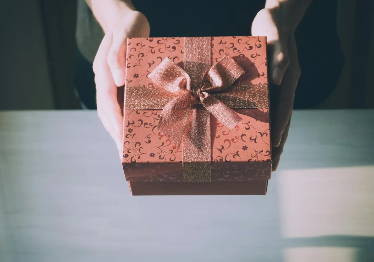 a person holding a red gift box with a bow, pexels contest winner, brown, square, engraved, manuka