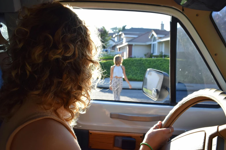 a woman sitting in the driver's seat of a car, by Carey Morris, unsplash, walking through a suburb, avatar image, van, half image