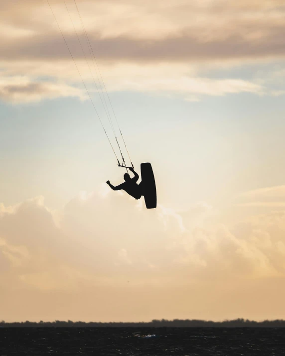 a man flying through the air while riding a kiteboard, by Jan Tengnagel, pexels contest winner, arabesque, lgbtq, instagram story, soft morning light, non-binary