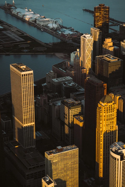 a city with lots of tall buildings next to a body of water, by Andrew Domachowski, pexels contest winner, back lit vertigo fear of heights, 8k detail post processing, late afternoon light, chicago