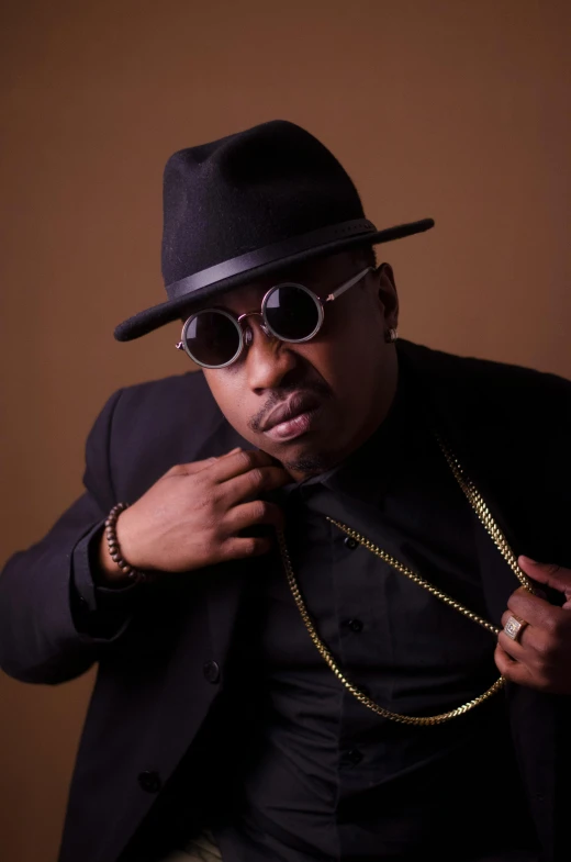 a man wearing a black hat and sunglasses, an album cover, inspired by Francis Ernest Jackson, big moe, shot in the photo studio, confident pose, neo soul