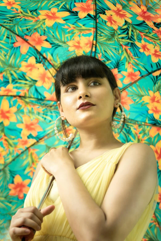 a woman in a yellow dress holding an umbrella, an album cover, pexels, hurufiyya, bollywood, headshot profile picture, floral, betty la fea