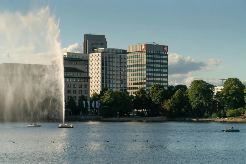 a large body of water with a fountain in the middle of it, by Mathias Kollros, tech city in the background, norrlandsskog, high-quality photo, fan favorite