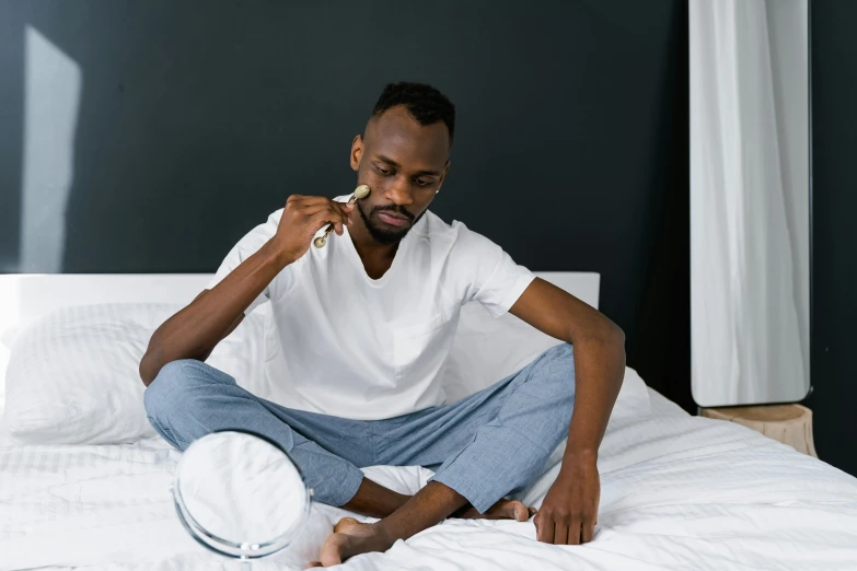 a man sitting on a bed brushing his teeth, inspired by Paul Georges, trending on pexels, grey skin, sad men, jaylen brown, white bed