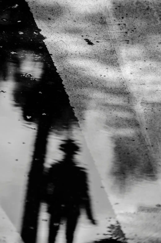 a black and white photo of a person holding an umbrella, inspired by Sergio Larraín, lyrical abstraction, reflection on the oil, wet asphalt, ( ( abstract ) ), noir photorealism