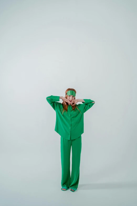 a woman in a green suit posing for a picture, by Gavin Hamilton, trending on pexels, visual art, wearing pajamas, blindfolded, in a white room, young redhead girl in motion