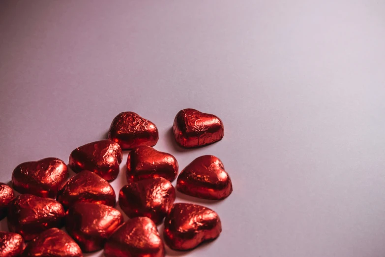 a pile of chocolate hearts sitting on top of a table, pexels, photorealism, metallic red, product photograph, gif, silver