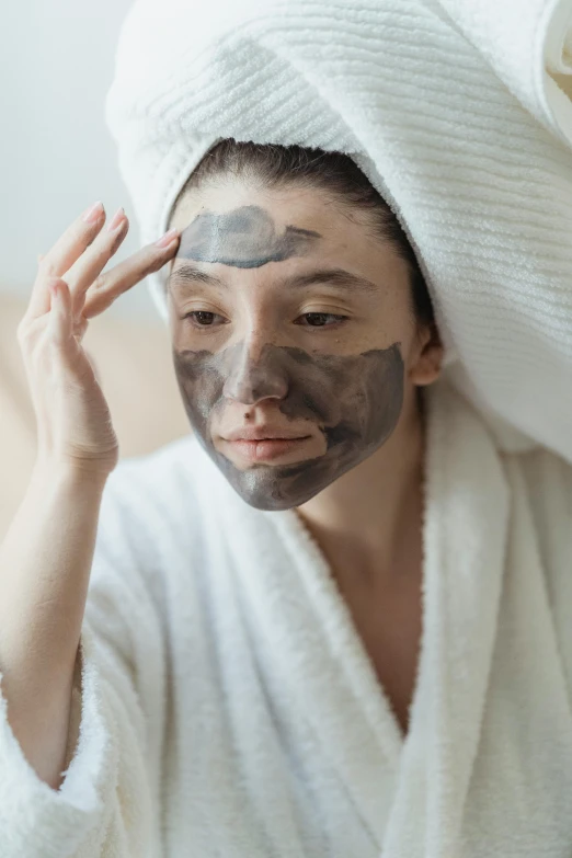 a woman with a towel wrapped around her head, a portrait, trending on pexels, renaissance, face mask, hard clay, brunette, wearing a grey robe