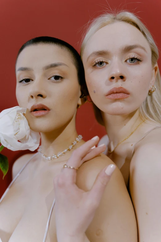 two women standing next to each other holding flowers, inspired by Elsa Bleda, renaissance, bone jewellery, girl with a pearl earringl, off - white collection, with red haze