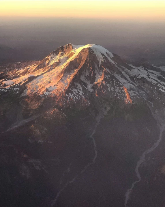 an aerial view of a snow covered mountain, an album cover, unsplash contest winner, hurufiyya, golden hour lighing, volcano, summer morning light, plane light