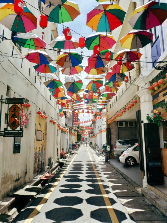 a street filled with lots of colorful umbrellas hanging from the ceiling, set on singaporean aesthetic, profile image, whitewashed buildings, kuala lumpur