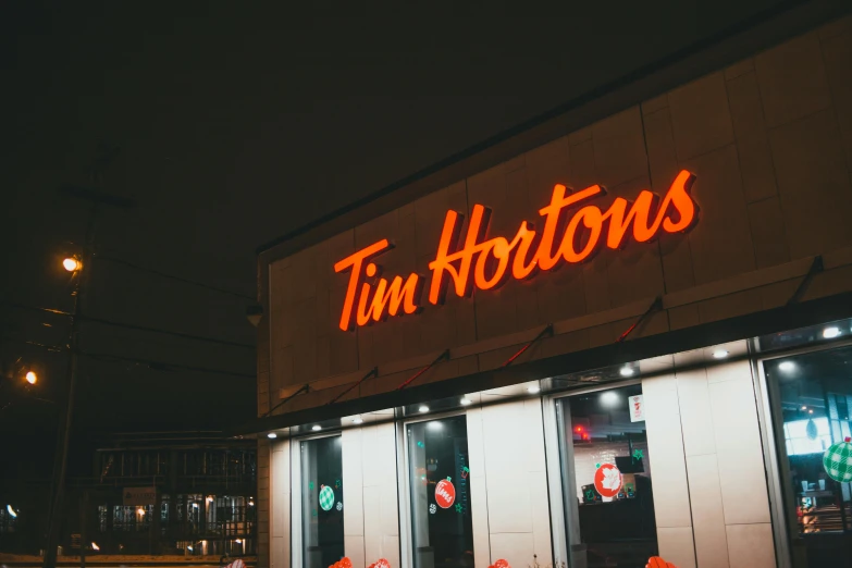 a restaurant with a neon sign that says tim hortons, an album cover, by Tom Palin, trending on unsplash, tonalism, timothee chalamet, profile image, ( ( theatrical ) ), taverns nighttime lifestyle