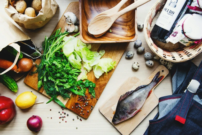 a wooden cutting board topped with lots of food, a photo, unsplash, renaissance, fish scales, cutting a salad, white apron, 🦩🪐🐞👩🏻🦳