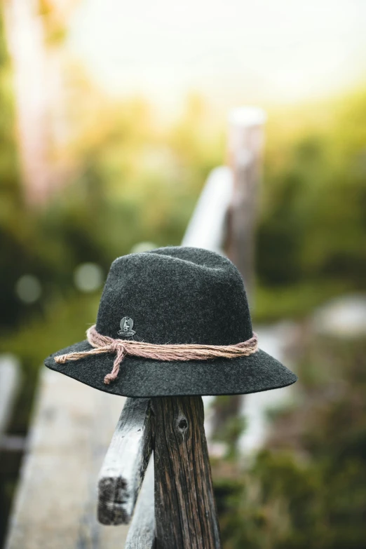a hat sitting on top of a wooden bench, in gunmetal grey, adventurer, thumbnail, waist - shot