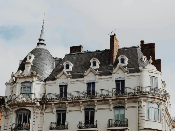 a large building with a clock on the front of it, by Raphaël Collin, pexels contest winner, art nouveau, white houses, rennes - le - chateau, city rooftop, view from side