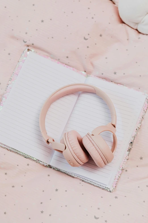 a pair of headphones sitting on top of a notebook, by Julia Pishtar, pastel pink skin tone, ((pink)), pink, multiple stories