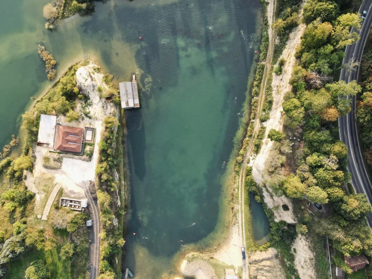 an aerial view of a large body of water, by Attila Meszlenyi, pexels contest winner, hurufiyya, old lumber mill remains, rock quarry location, thumbnail, swimming