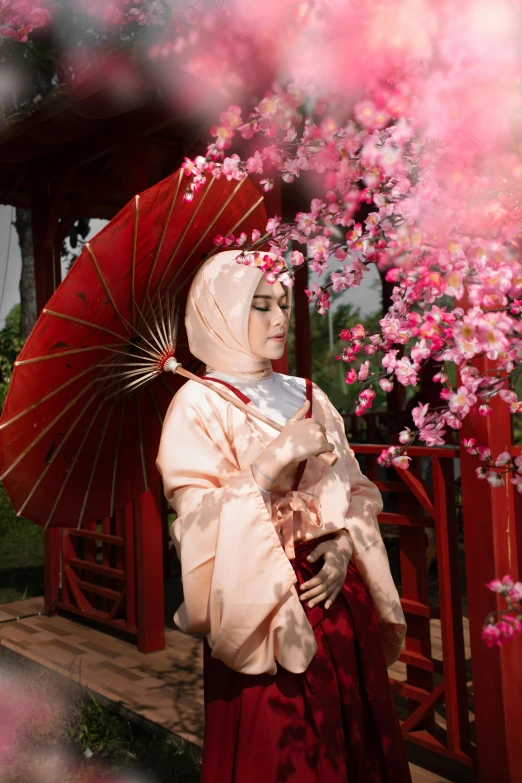 a woman in a red dress holding an umbrella, inspired by Uemura Shōen, pexels contest winner, hijab, sakura flowers, cinematic outfit photo, wearing silver silk robe