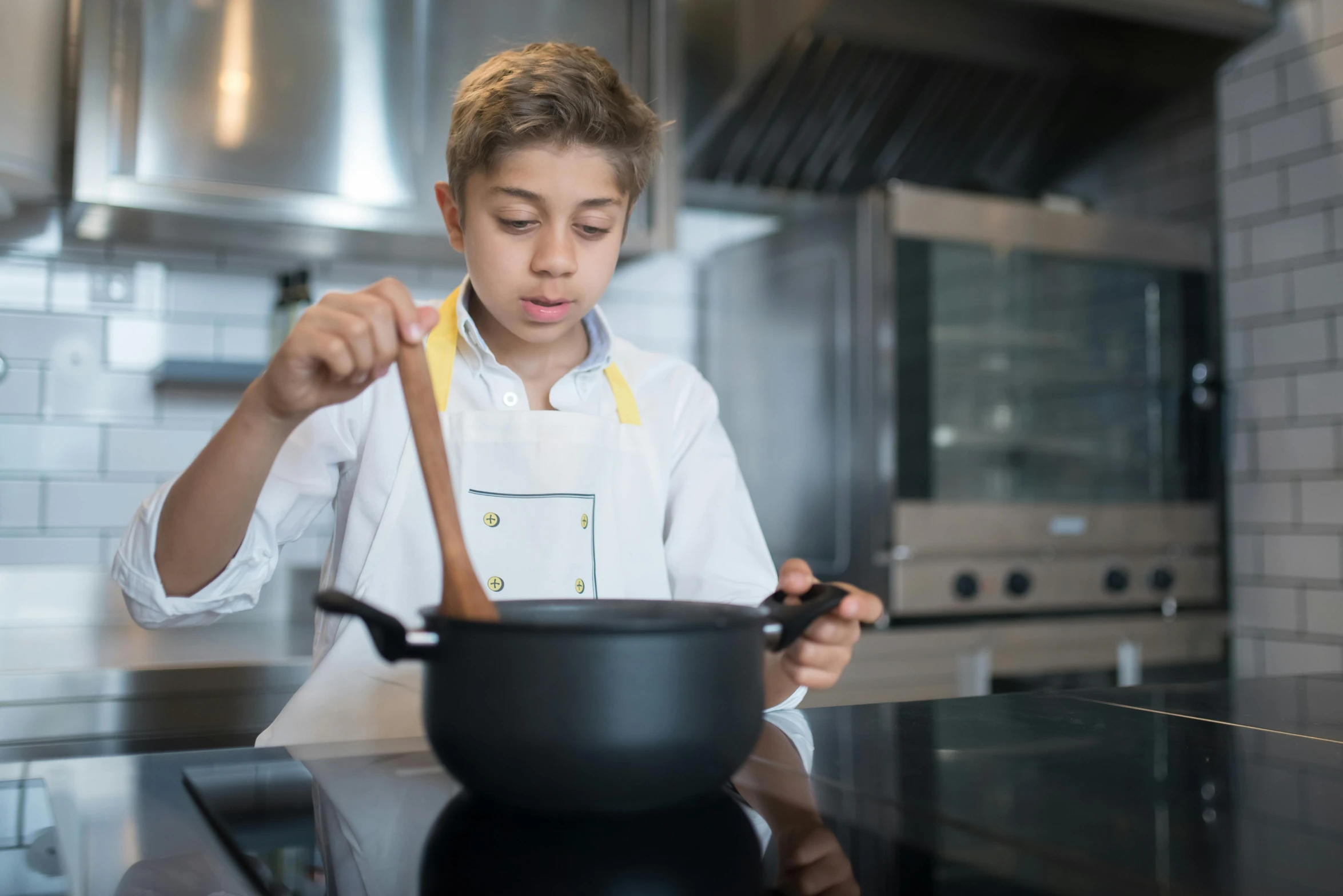 a young boy preparing food in a kitchen, inspired by Charles Le Roux, pexels contest winner, braziers, head and shoulder shot, cast, ignant