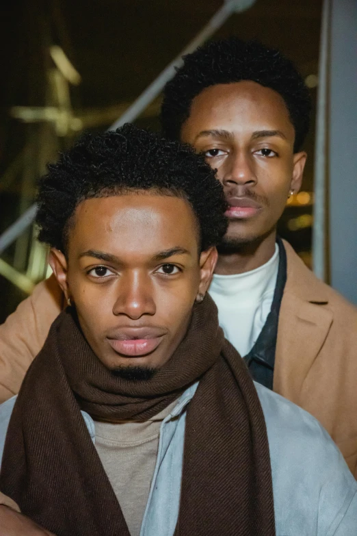 a couple of men standing next to each other, an album cover, by Stokely Webster, renaissance, scarf, serious and stern expression, ( brown skin ), college