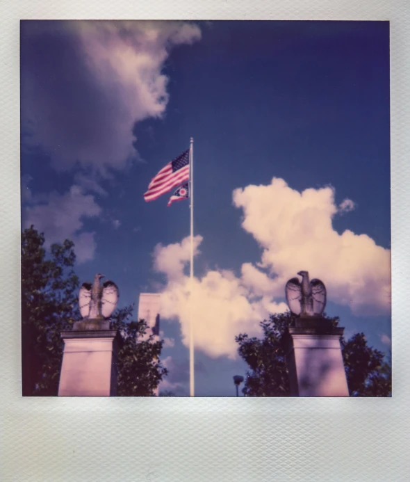 a flag that is flying in the sky, a polaroid photo, by Carey Morris, unsplash, american romanticism, olmsted, photo taken on fujifilm superia, historical photo, colored photo