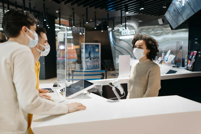 a couple of people that are standing in front of a counter, a hologram, pexels, hyperrealism, medical mask, malls, brown, customers