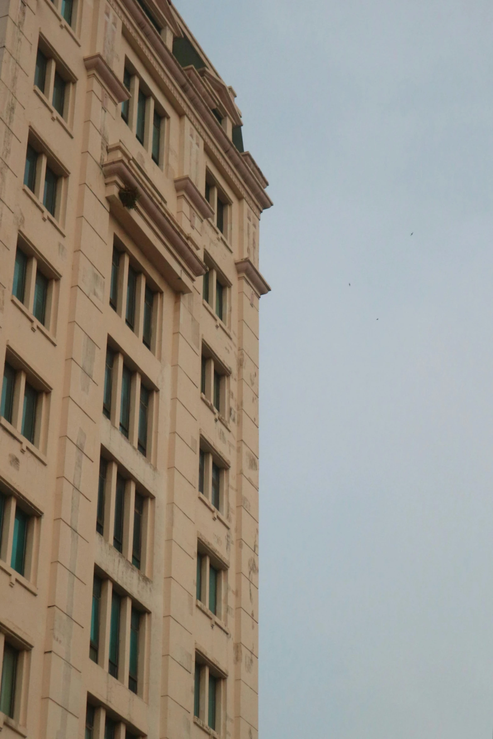 a clock that is on the side of a building, bangalore, viewed from the ocean, low quality photo, window ( city )