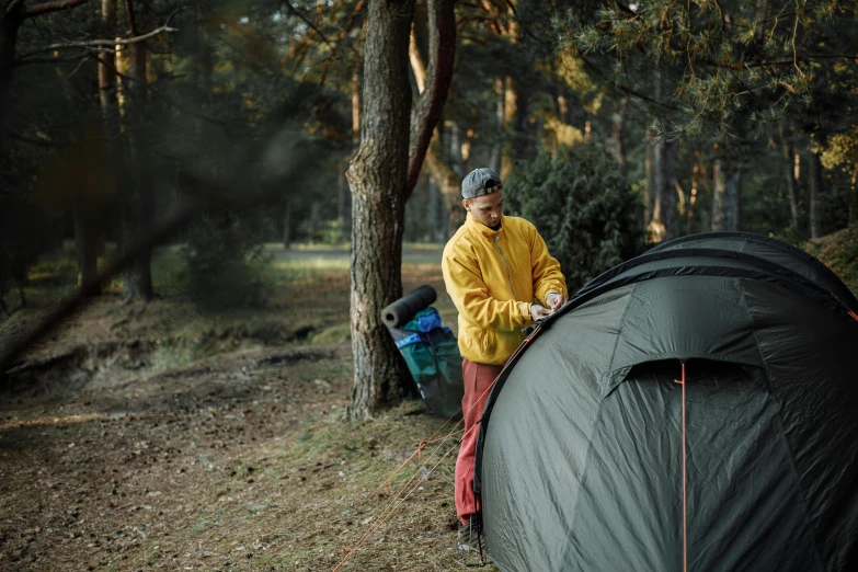 a man setting up a tent in the woods, by Jan Tengnagel, pexels contest winner, hurufiyya, trees in the background, avatar image, touring, panorama shot