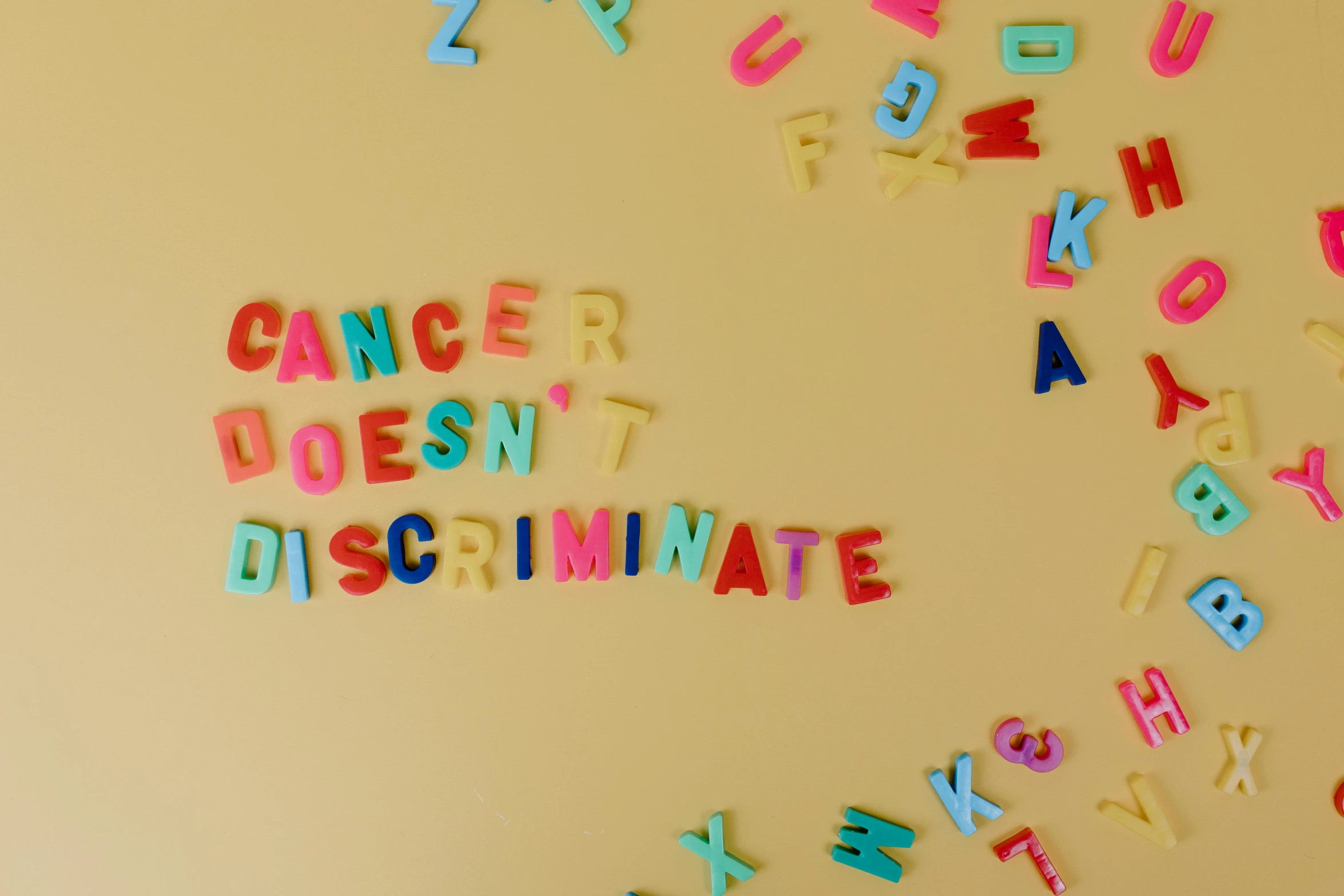 a refrigerator with magnets that say cancer doesn't discriminate, by Julia Pishtar, pexels, feminist art, confetti, alphabet soup, fluorescent, walls with tone of yellow