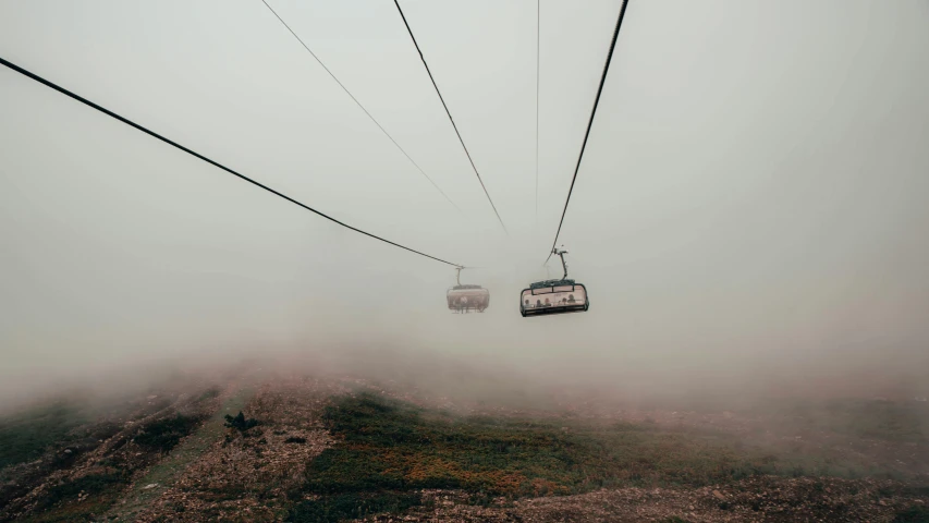 a couple of chairs sitting on top of a hill, by Tobias Stimmer, unsplash contest winner, fantastic realism, trams, dust floats in the air, overcast, cables