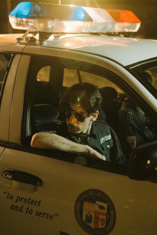 a man sitting in the driver's seat of a police car, an album cover, reddit, photorealism, kevin mitnick as a bank robber, alessio albi, medium - shot, bright lights