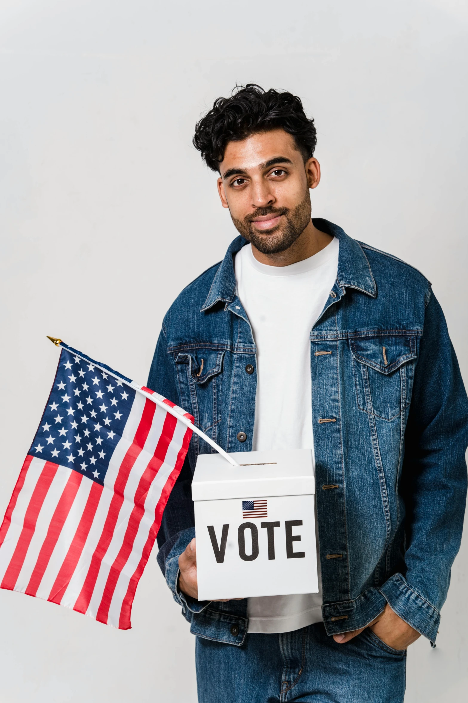 a man holding an american flag and a voting box, a colorized photo, trending on unsplash, a portrait of rahul kohli, 15081959 21121991 01012000 4k, model posing, ashteroth