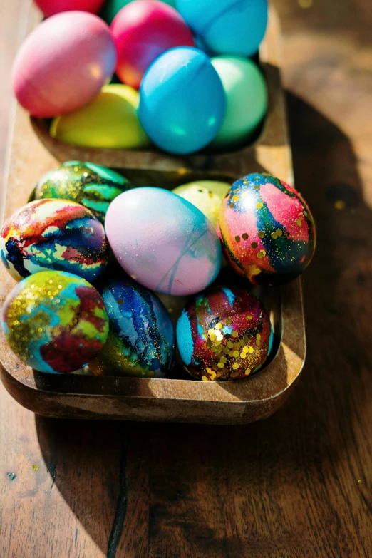 a wooden tray filled with easter eggs on top of a wooden table, splattered paint, black opals, multiple stories, vapor