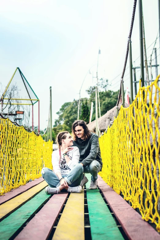 a woman and a child sitting on a colorful bridge, adventure playground, non-binary, instagram picture, orelsan