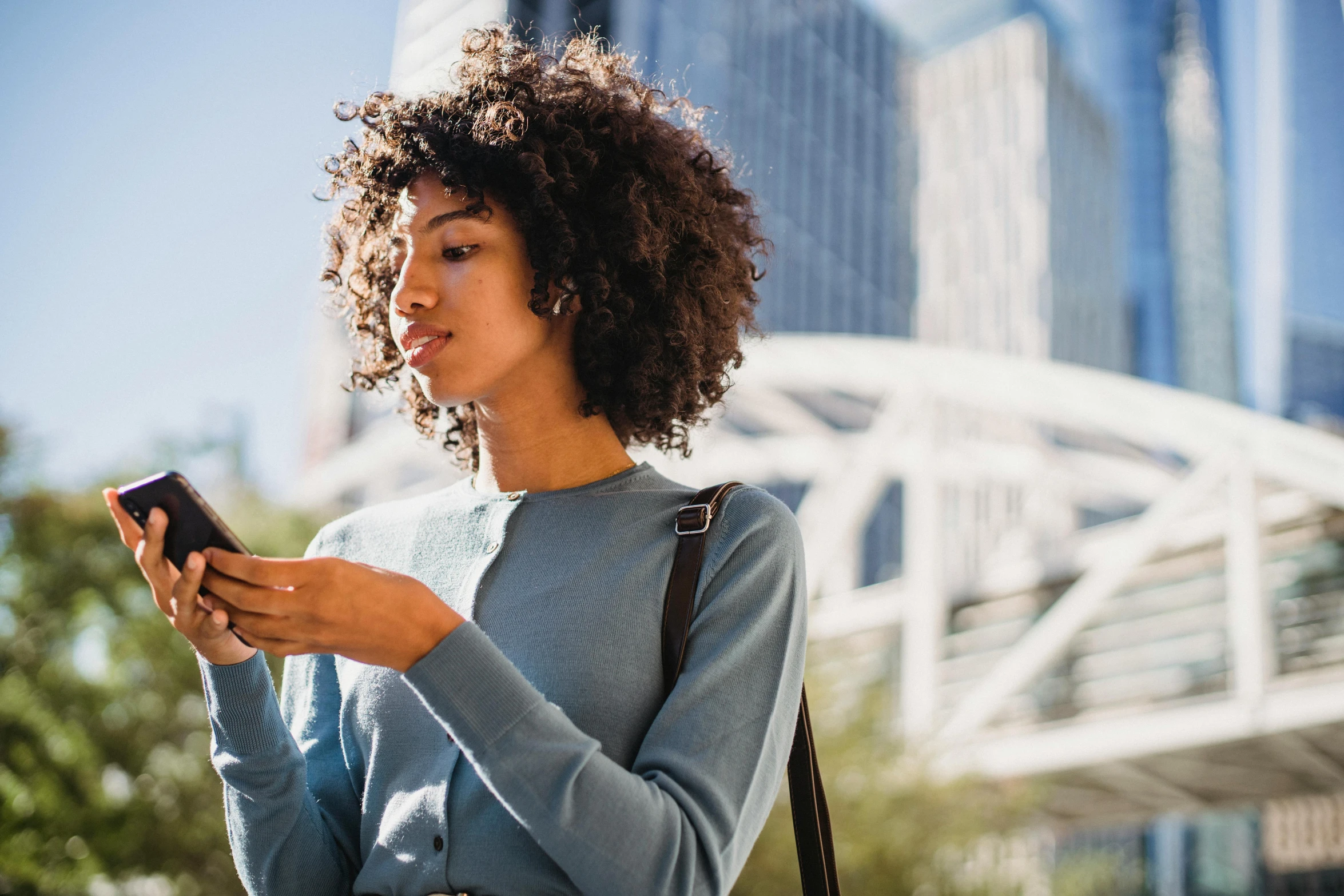 a close up of a person holding a cell phone, trending on pexels, beautiful city black woman only, avatar image, thumbnail, schools