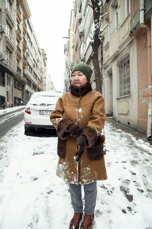 a woman standing in the middle of a snowy street, by Carlo Martini, cover photo portrait of du juan, reportage, brown, street wear