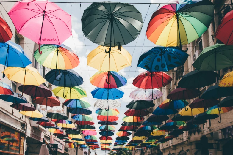 a street filled with lots of colorful umbrellas, trending on unsplash, overlay, fan favorite, things hanging from ceiling, lgbtq