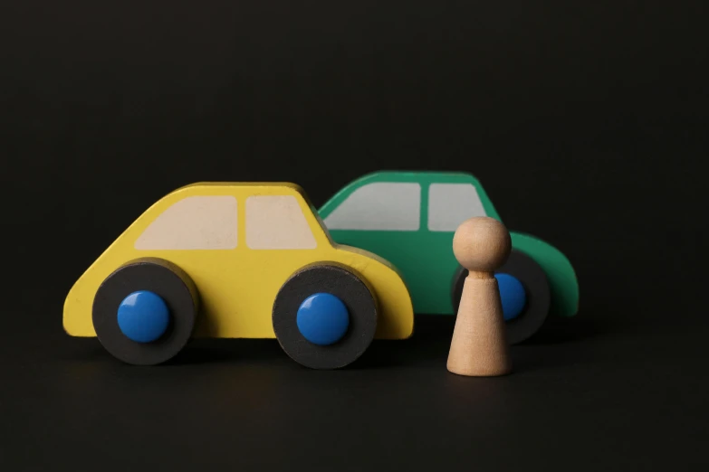 a couple of toy cars sitting next to each other, a 3D render, inspired by Christopher Wood, unsplash, visual art, holding a wood piece, siluettes, over his shoulder, children's toy