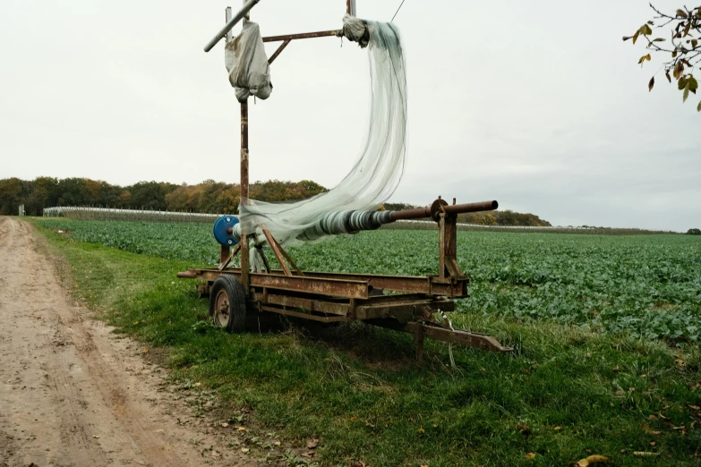 a truck driving down a dirt road next to a field, an album cover, by Attila Meszlenyi, renaissance, loom, vegetable, high res photograph, fisherman