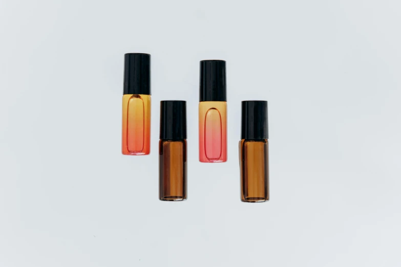 three bottles of perfume on a white background, an album cover, unsplash, gradient red to yellow, 1 4 mm, amber, 4 colors