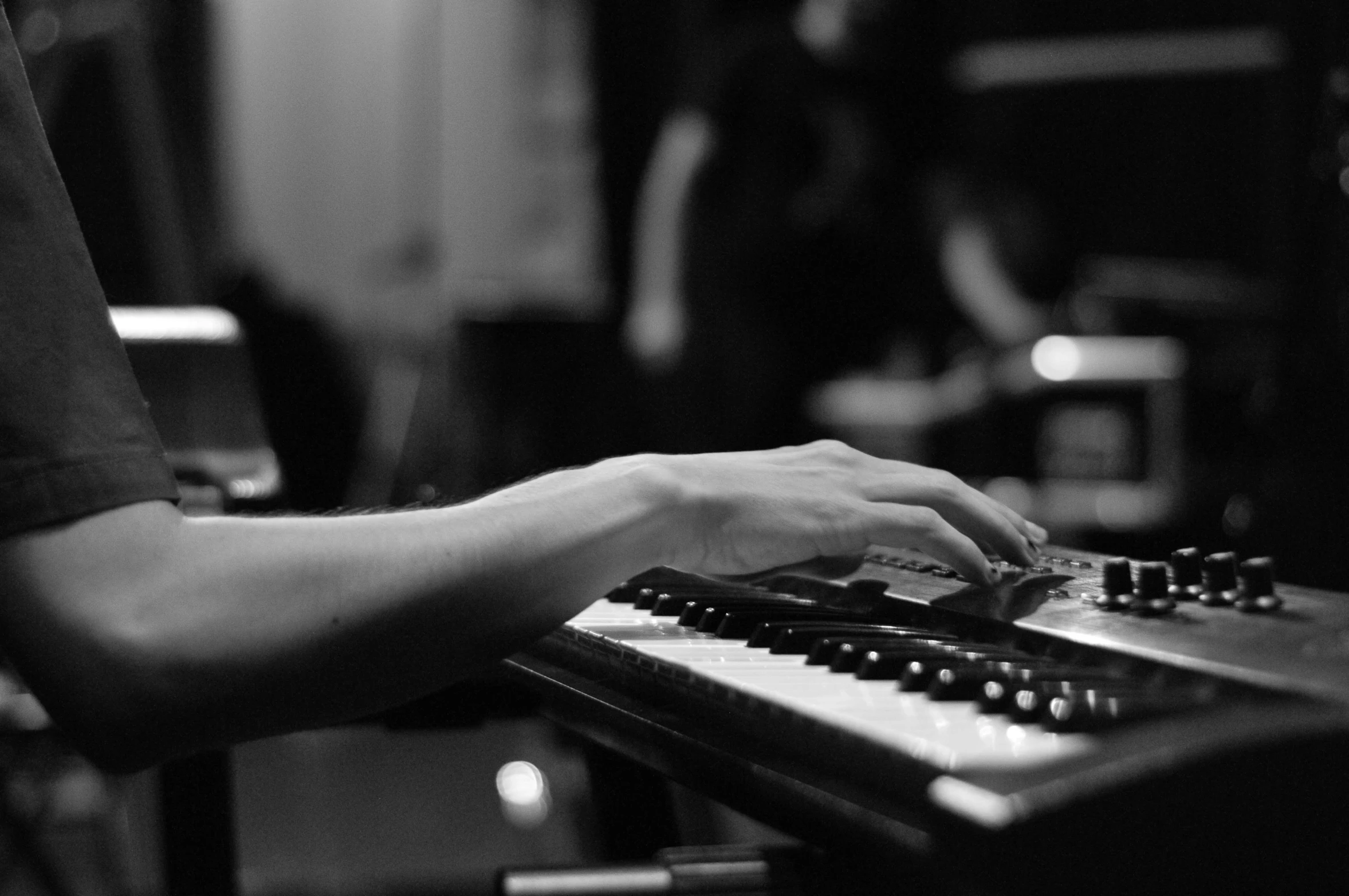 a close up of a person playing a keyboard, a black and white photo, by Mathias Kollros, pexels, tiffany dover, backroom background, detailed »