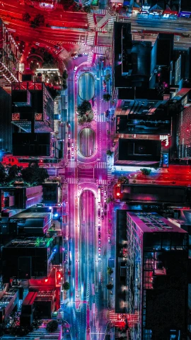 an aerial view of a city at night, inspired by Beeple, unsplash contest winner, neon road, pink and blue lighting, new york streets, unsplash photo contest winner