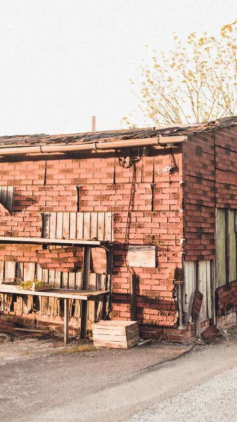 a red brick building sitting on the side of a road, an album cover, inspired by Elsa Bleda, unsplash, scrapyard architecture, inside a shed, profile image, panoramic shot