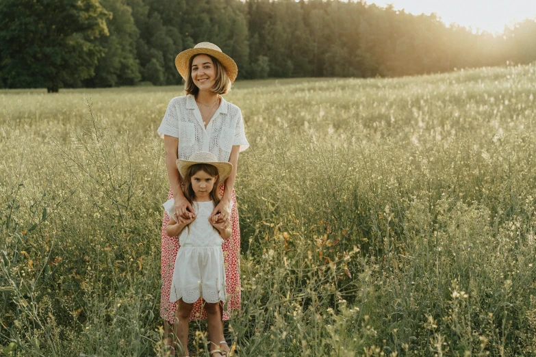 a woman and a little girl standing in a field, inspired by Elsa Beskow, pexels contest winner, white straw flat brimmed hat, photoshoot for skincare brand, rectangle, avatar image