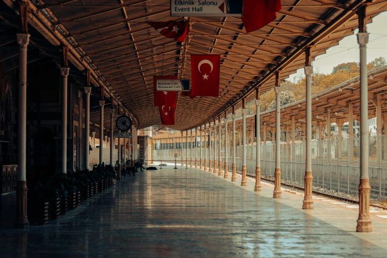 a train station with several flags hanging from the ceiling, by Yasar Vurdem, pexels contest winner, art nouveau, turkey, empty streets, 🚿🗝📝, profile image