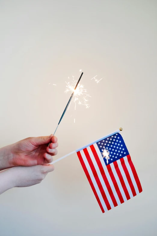 a person holding a sparkler and an american flag, a picture, official product photo, tiny sticks, shiny crisp finish, a super-smart