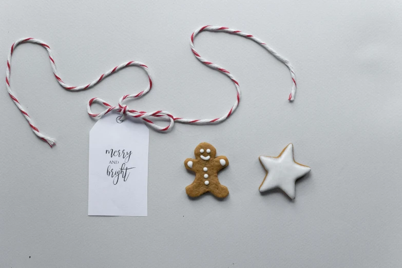 a couple of cookies sitting on top of a table, by Emma Andijewska, pexels contest winner, minimalism, fairy lights, bright white porcelain, ribbon, asset on grey background