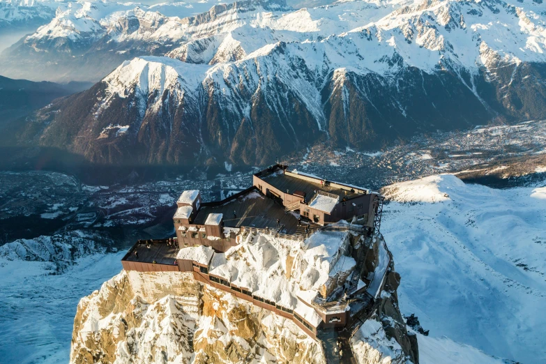 a large building sitting on top of a snow covered mountain, by Daniël Mijtens, pexels contest winner, baroque, aerial footage, cliffside, herzog de meuron, icy mountains in the background