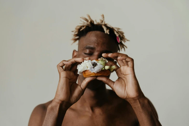 a man with dreadlocks eating a doughnut, inspired by Barthélemy Menn, trending on pexels, beefcake pose, minimalist photo, man is with black skin, neanderthal people eating sushi